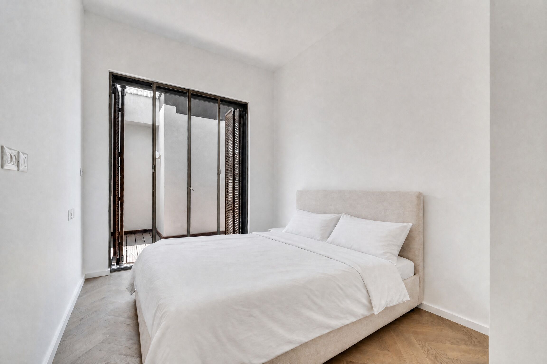 A bedroom with a bed, a wardrobe, and a door.