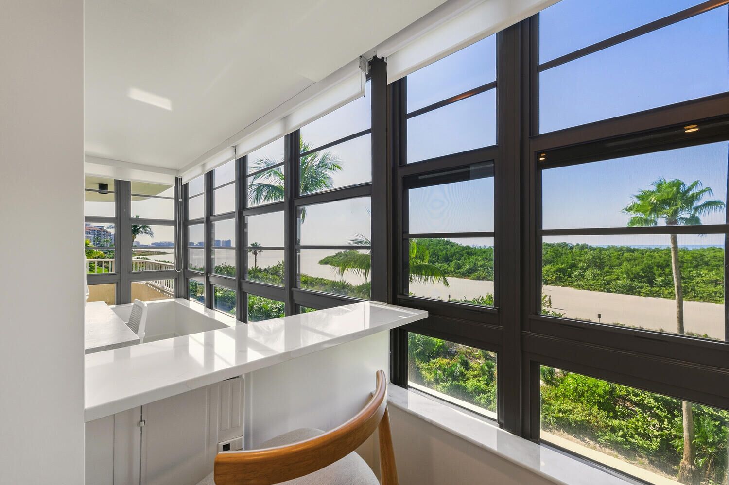 A modern kitchen with a large window overlooking a lush landscape.