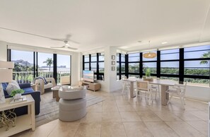 A spacious living area with a balcony, a dining area, and a TV. - South Seas Beachfront Unit 311 – Marco Island, Florida (Marco Island)