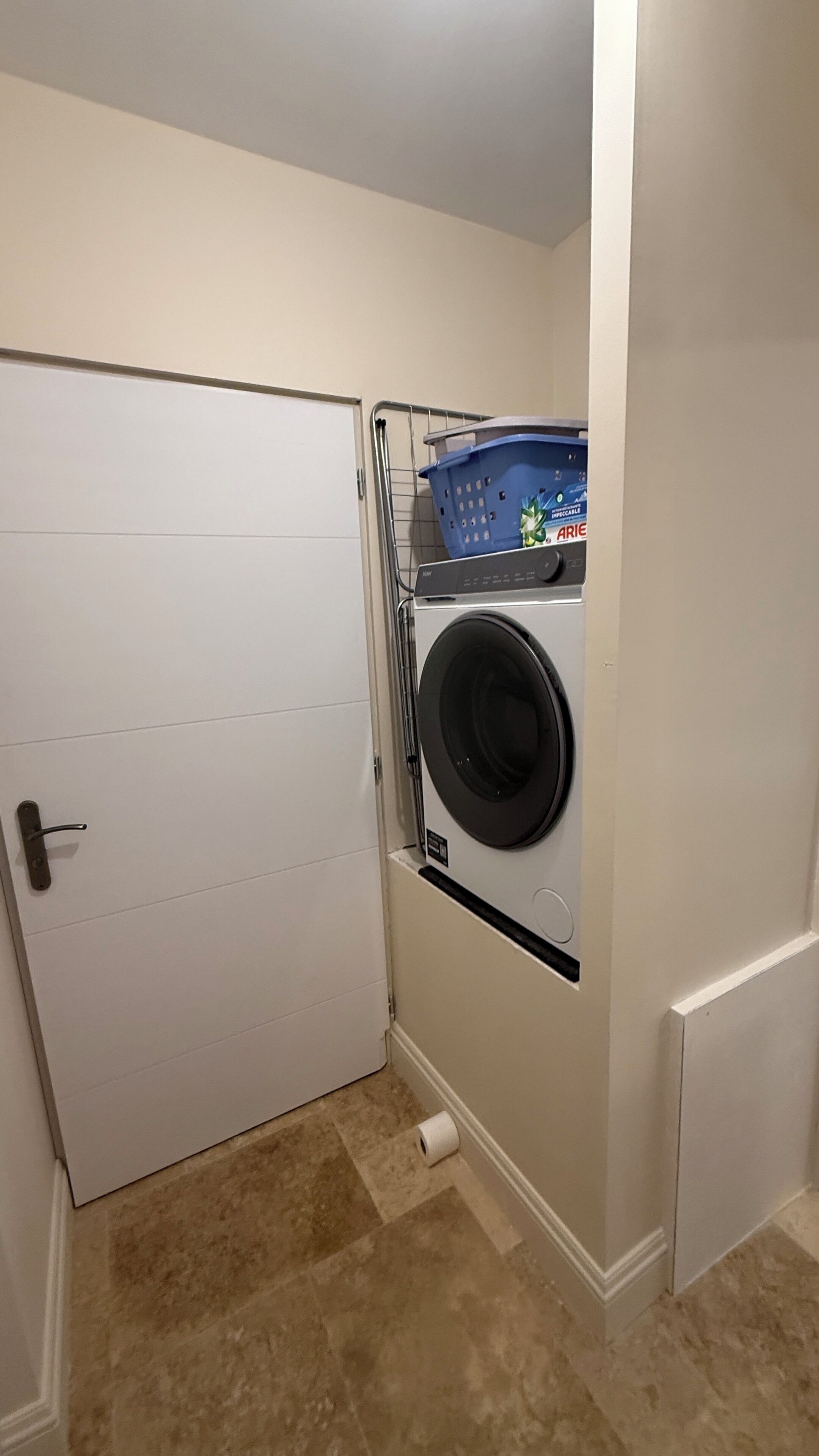 A laundry room with a washing machine, a dryer, and a door.