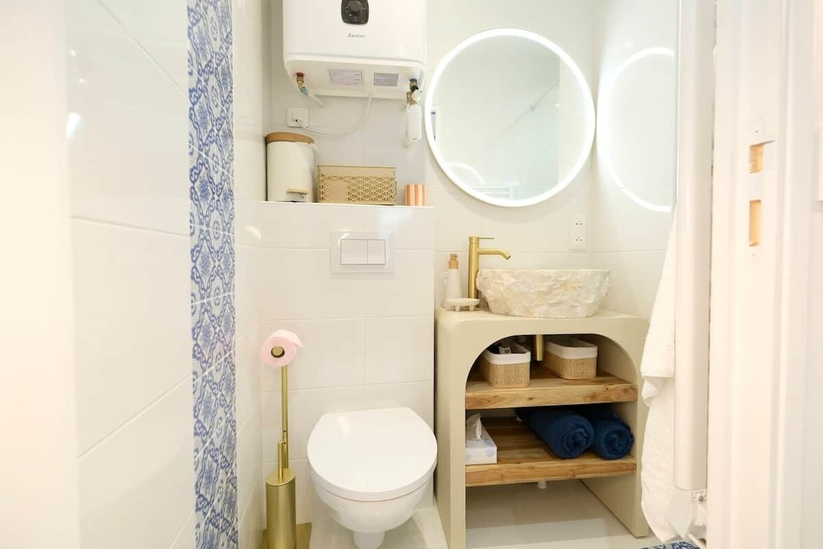 Un bagno con il water, un lavandino con specchio e un portasciugamani.