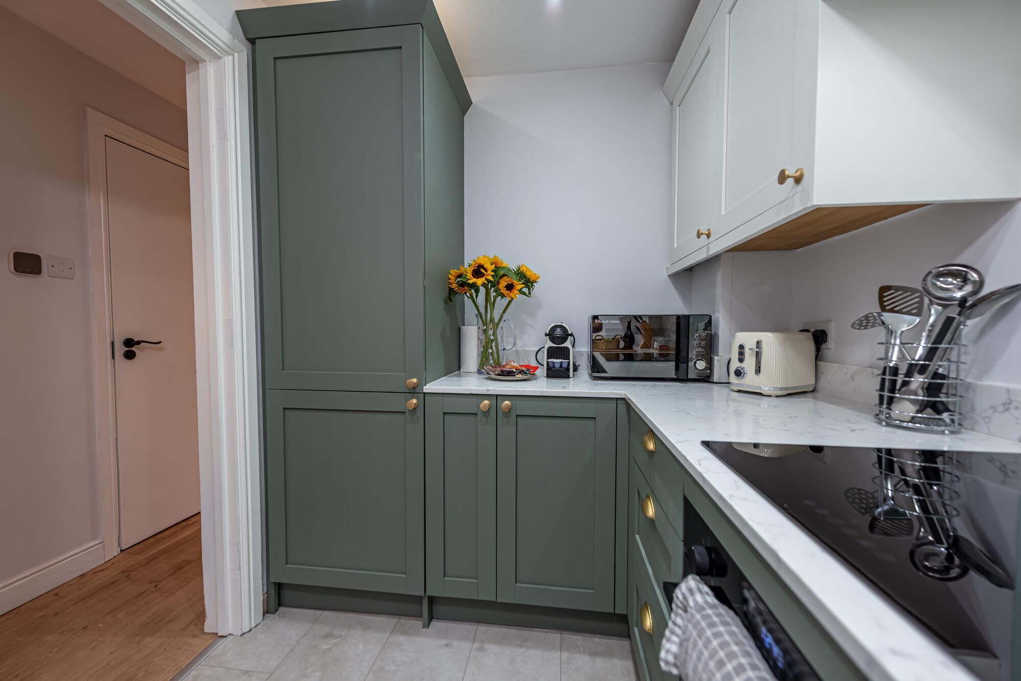 A kitchen with a microwave, toaster, and a coffee maker on the counter.