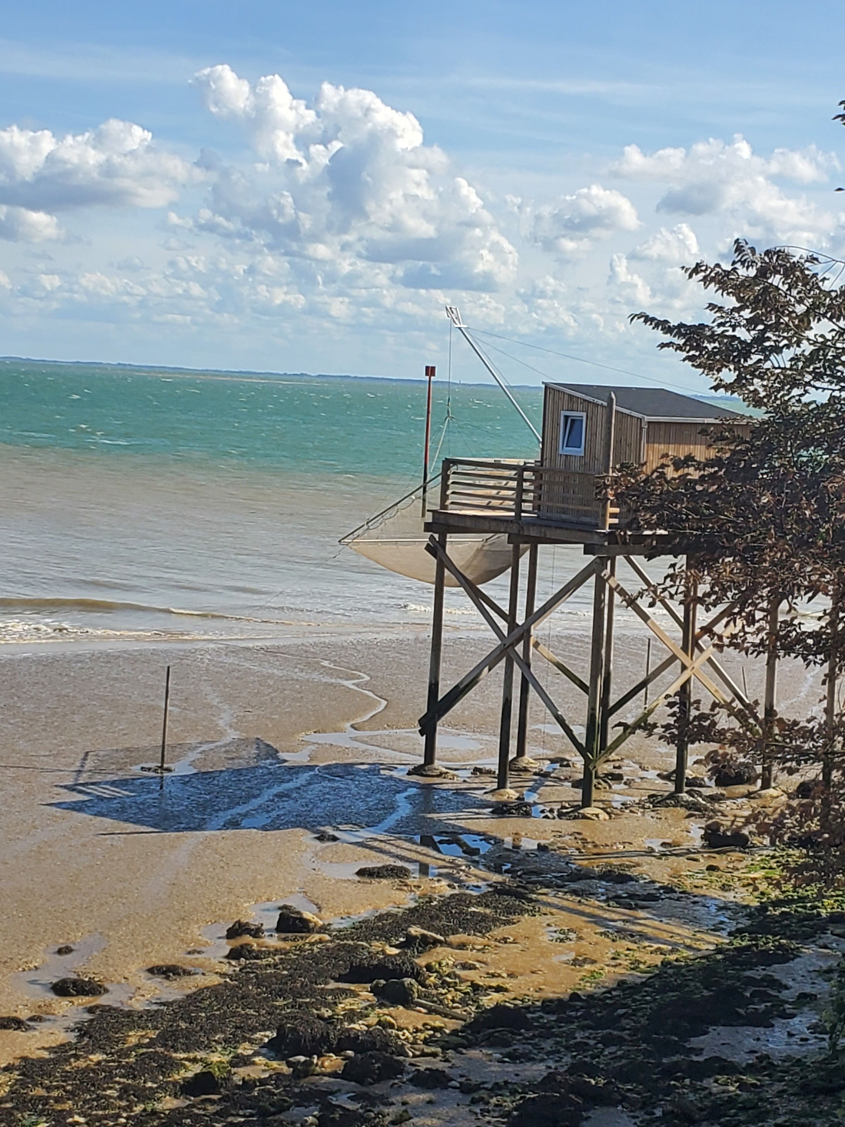 A wooden structure on stilts by the sea with a clear view of the ocean.