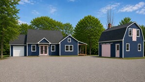 A two-story house with a garage, a covered porch, and a driveway.