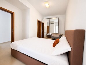 Ein Schlafzimmer mit einem Bett, einem Spiegel und einem Kleiderschrank.
