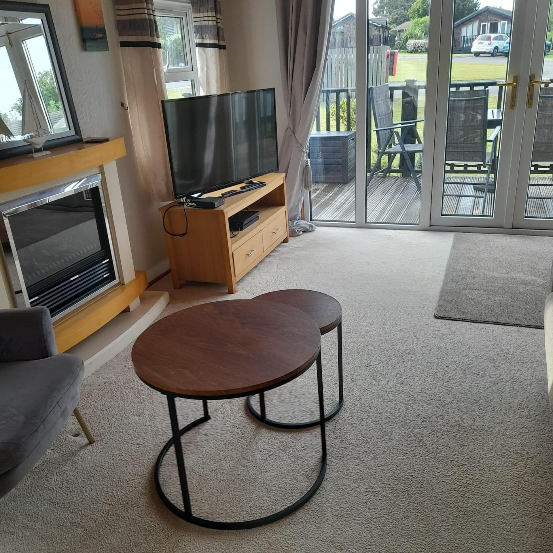 A living room with a flat-screen TV, a fireplace, a sofa, and a dining area with a table and chairs.