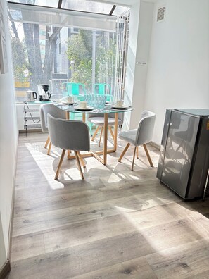 A modern kitchen with a glass table, grey chairs, and a stainless steel refrigerator. - Bright 2BR in the best area of Bogotá, near Park 93 (Bogotá)