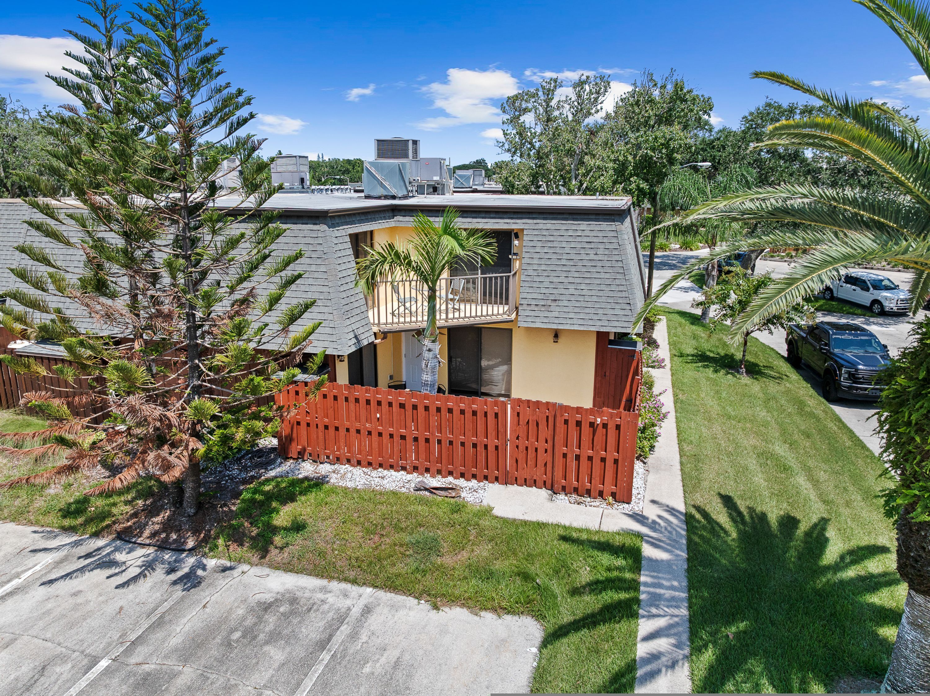 A residential property with a two-story house, a fenced yard, and a driveway.