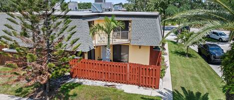 A residential property with a two-story house, a fenced yard, and a driveway.