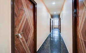A hallway with wooden doors and a tiled floor. - Classic Ramoji Film City (Hyderabad)