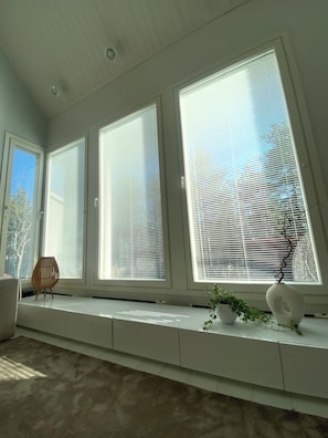 A room with large windows, a bench, and a potted plant. - Scandinavian Arctic Retreat in Rovaniemi – 3BR & Sauna (Rovaniemi)