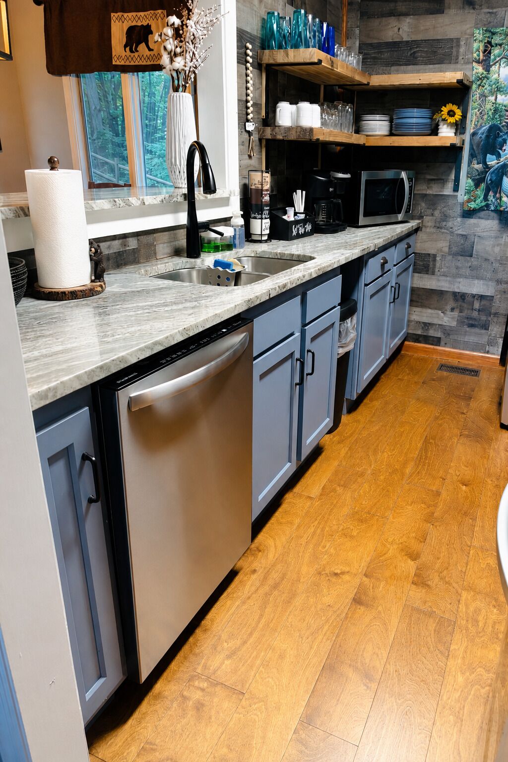 A kitchen with a dishwasher, a microwave, and a sink.