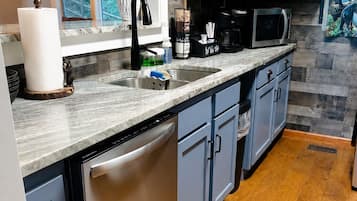 A kitchen with a dishwasher, a microwave, and a sink.
