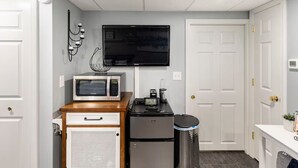 A compact kitchenette with a microwave, coffee maker, and refrigerator.
