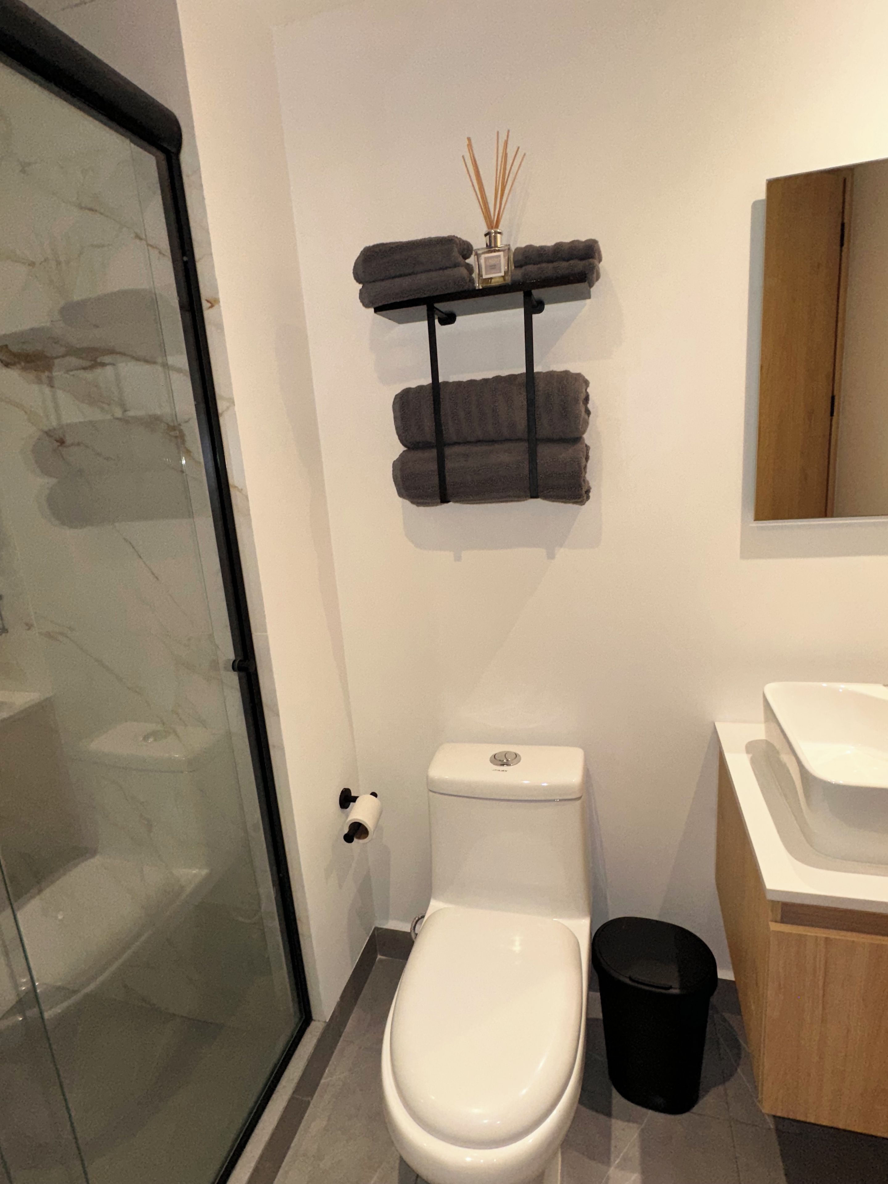 Une salle de bain équipée de toilettes, d’un bidet et d’une douche à parois de verre.