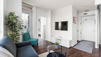 A modern living room with a sofa, teal chair, and a coffee table.