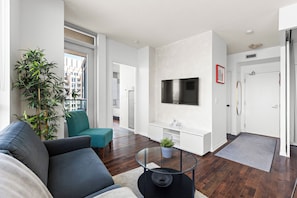 A modern living room with a sofa, teal chair, and a coffee table.