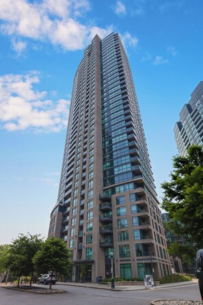 Un edificio de gran altura con varios pisos, ventanas amplias y un diseño arquitectónico moderno.