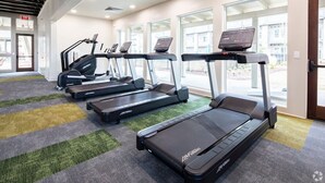 A gym with treadmills, exercise bikes, and a carpeted floor. - Resort-Style Stay | Pool, Gym | Near Toyota Field (Madison)