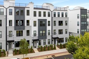 A multi-story residential building with a uniform exterior, featuring a series of balconies and a central entrance.