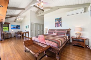 A spacious bedroom with a large bed, wooden furniture, and a ceiling fan. - Island Time Retreat by Gather: Oceanfront Access (Kamuela)