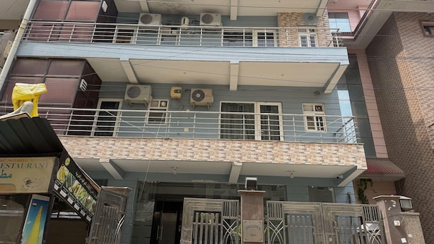 A multi-story building with balconies, air conditioning units, and a gated entrance.