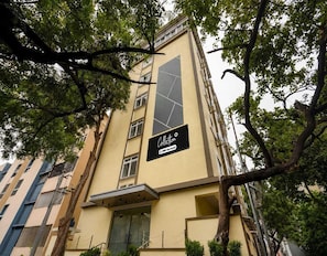 A multi-story building with a vertical sign that reads 'Collection OYO-Serviced.' - Deluxe Brigade Inn (Bengaluru)