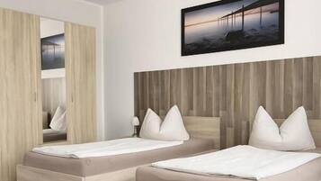 A modern bedroom with two single beds, a wooden headboard, and a large mirror.