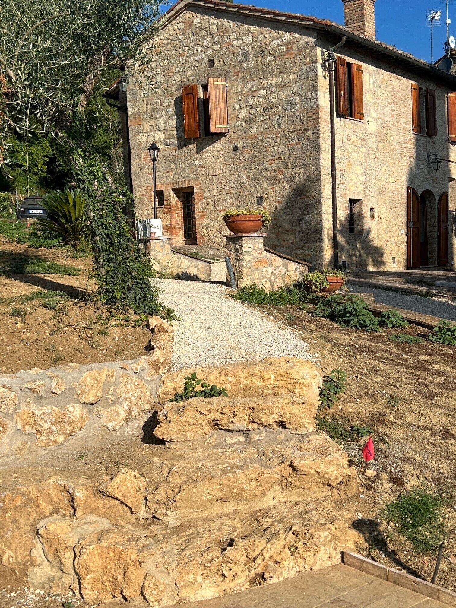 Un edificio de piedra con un camino de grava que lleva a la entrada.