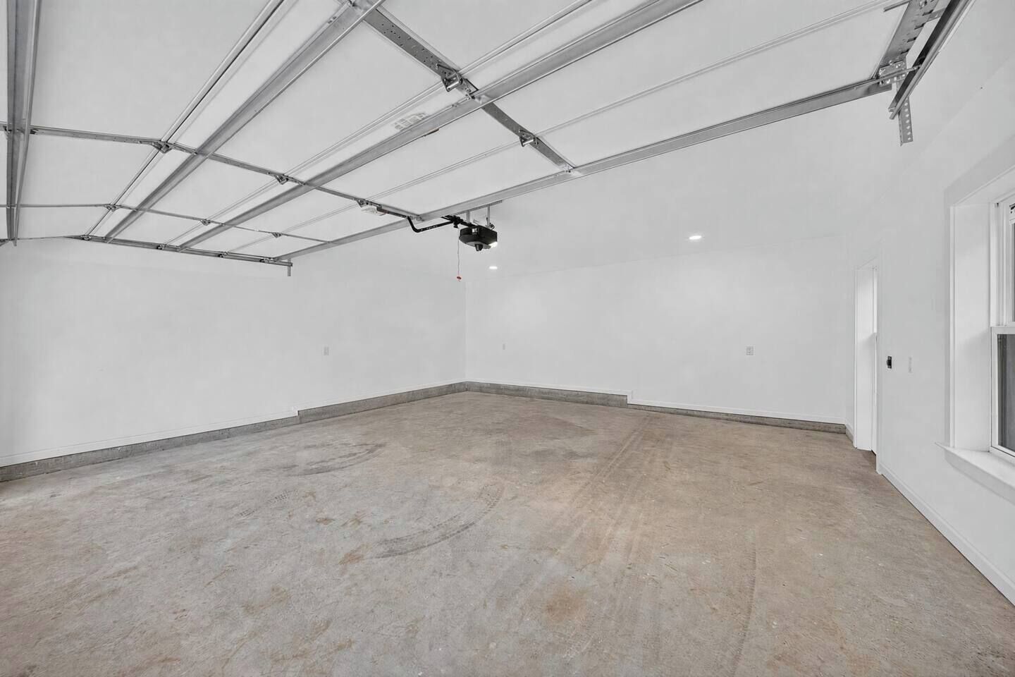 A spacious, empty room with a high ceiling and visible ductwork.