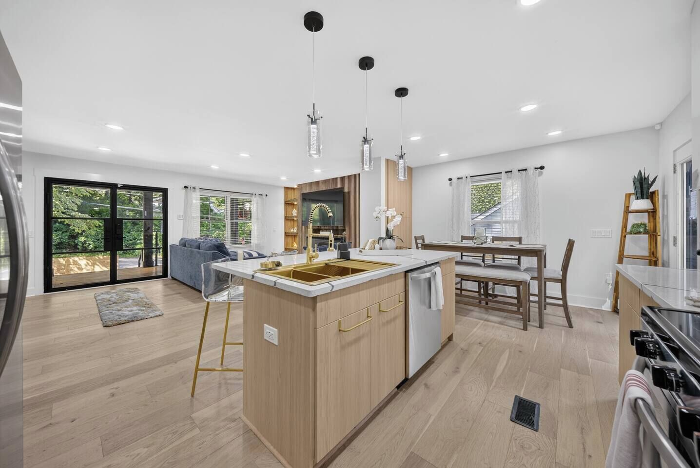 A modern kitchen with a central island, built-in appliances, and pendant lighting.