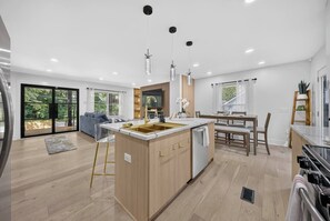A modern kitchen with a central island, built-in appliances, and pendant lighting.
