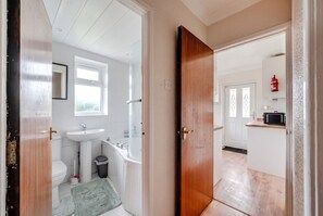 Un baño con inodoro, lavamanos y bañera.