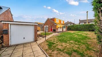 A residential area with a garage, a lawn, and houses with visible windows and doors.