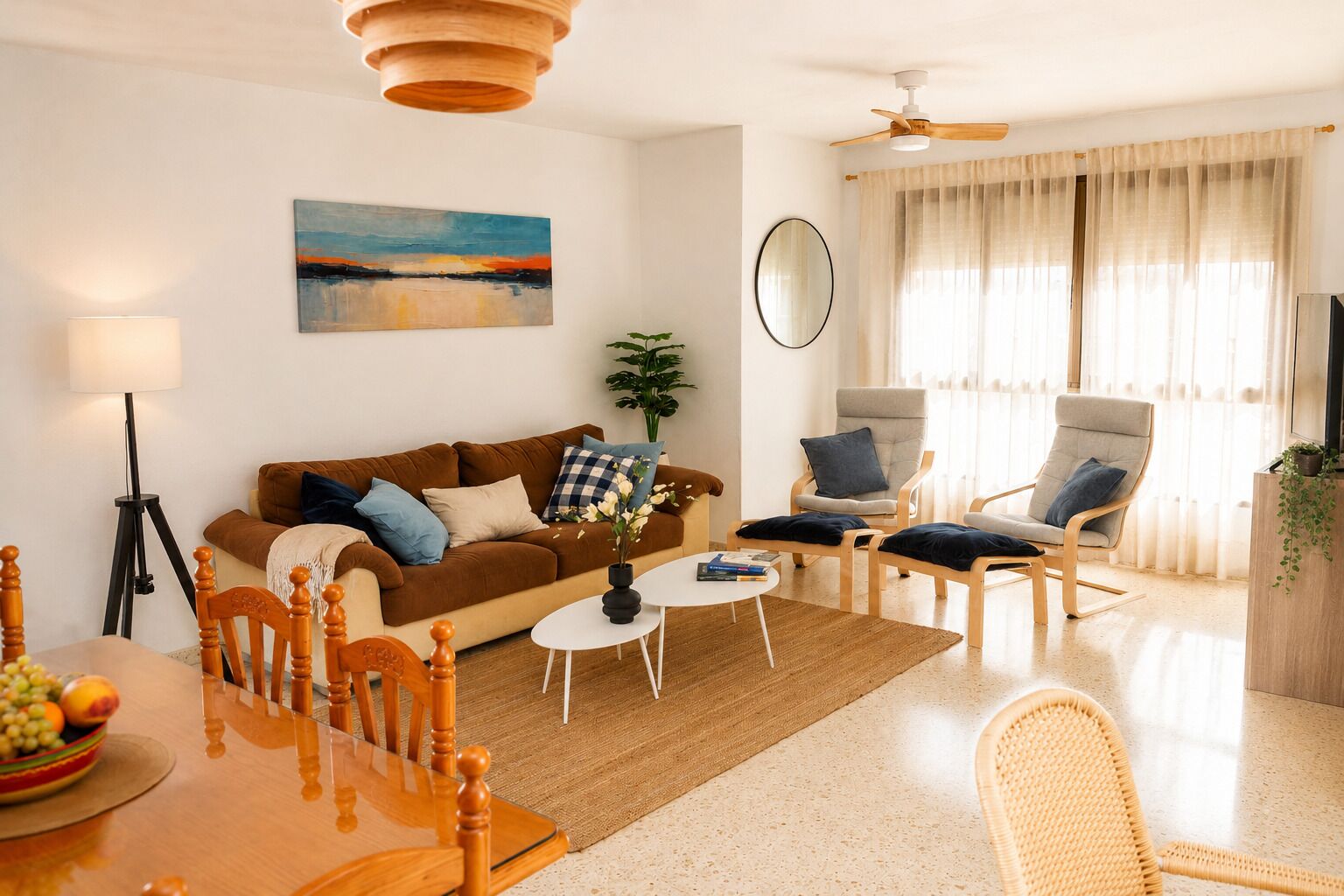 A modern living room with a sofa, armchairs, a dining table, and a ceiling fan.