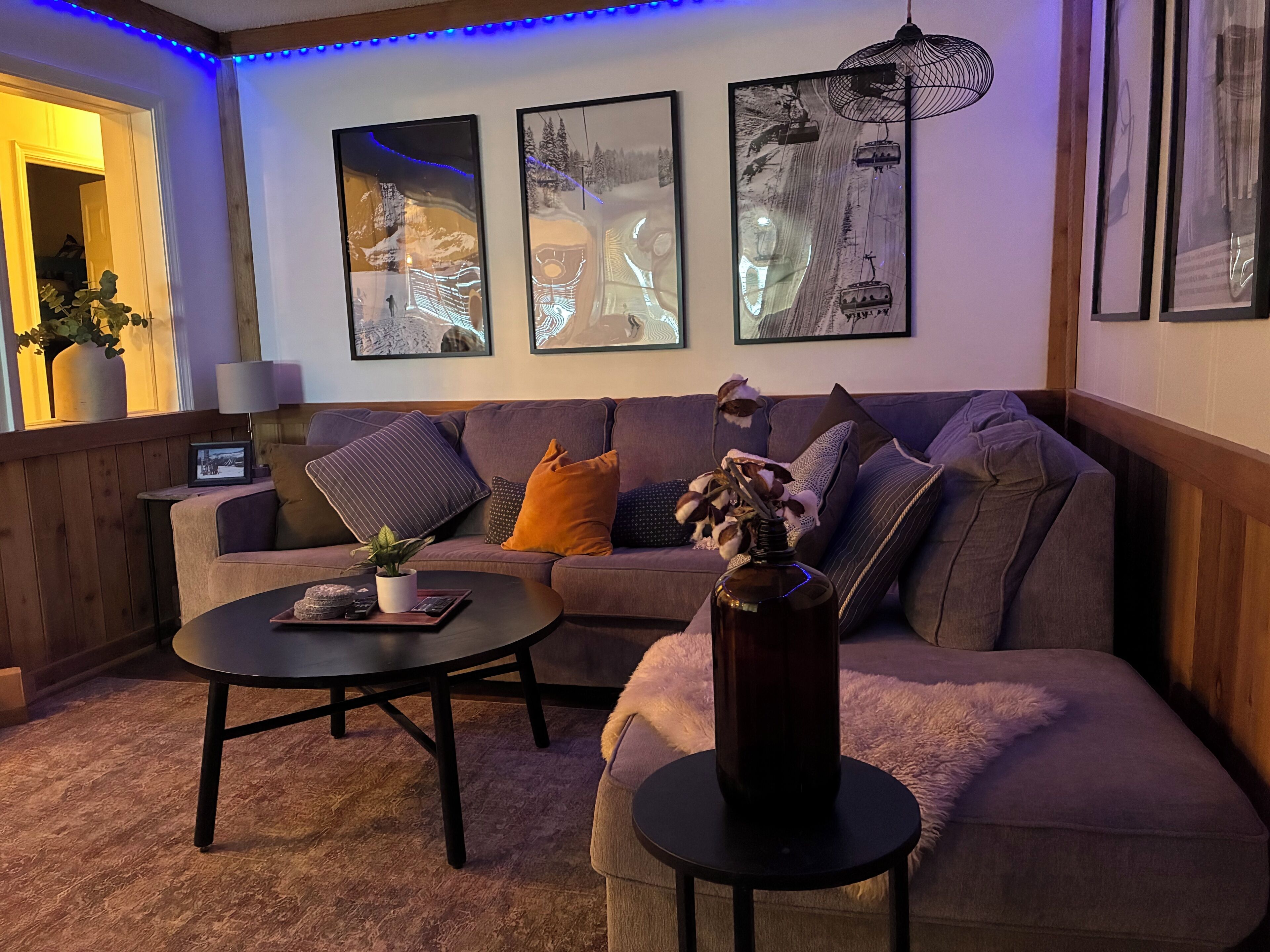 Un salon chaleureux avec un canapé, une table basse et des coussins décoratifs.