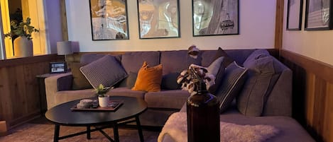 Una sala de estar acogedora con un sofá, una mesa de centro y almohadones decorativos.