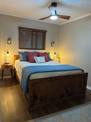 A bedroom with a wooden bed, a ceiling fan, a window with blinds, and two bedside lamps. - The Summit at 4848-3 Bedrooms, Steps to the Snowshoe Village and Slopes! (Snowshoe)
