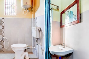 Un baño con inodoro, lavamanos, espejo y ventana.