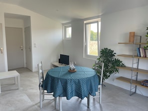 A room with a round table, chairs, a television, a window, and a bookshelf. - Préchacq-les-Bains (Préchacq-les-Bains)