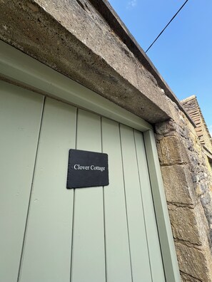 Una puerta con un letrero que dice 'Clover Cottage'.