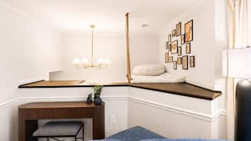 Habitación de esquina con un banco empotrado, una mesita, una lámpara colgante y una estantería con fotografías.
