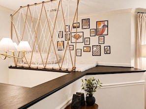 A room with a rope swing, framed artwork on the wall, and a plant on the floor. - The Monroe by Willow · Mt Pleasant · 4BR Residence (Washington)