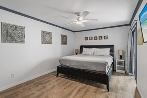 A bedroom with a bed, a ceiling fan, and decorative wall art. - Lakeview #9 - Paradise By The Gulf (Miramar Beach)