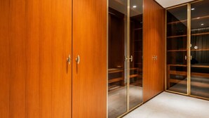 Une armoire en bois avec des portes miroir et un sol recouvert d’une moquette.
