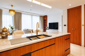 Eine moderne Küche mit einer großen Kochinsel, Holzschränken und einem integrierten Fernseher.