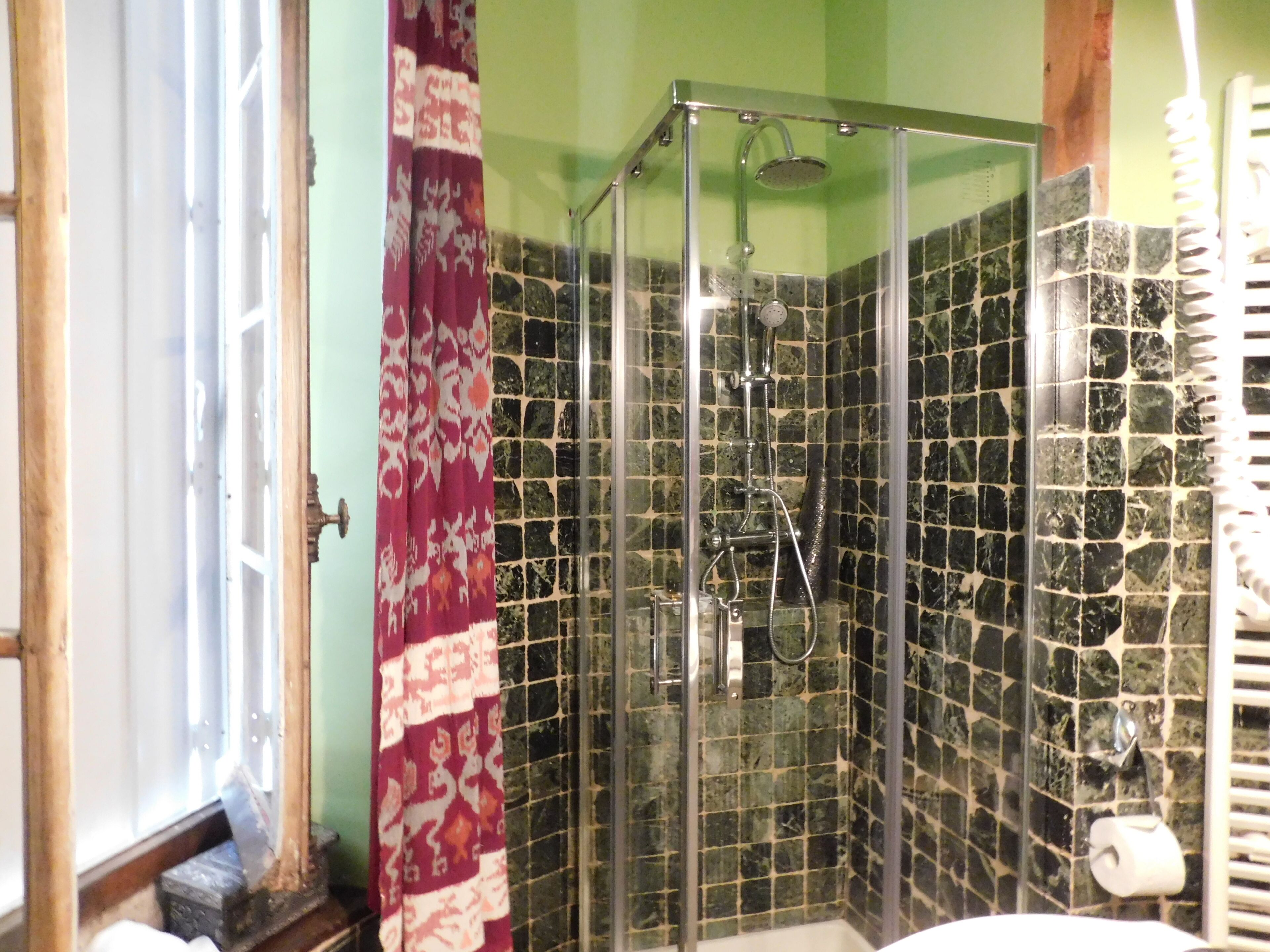 Une salle de bain avec une douche à parois de verre, des toilettes et un lavabo.