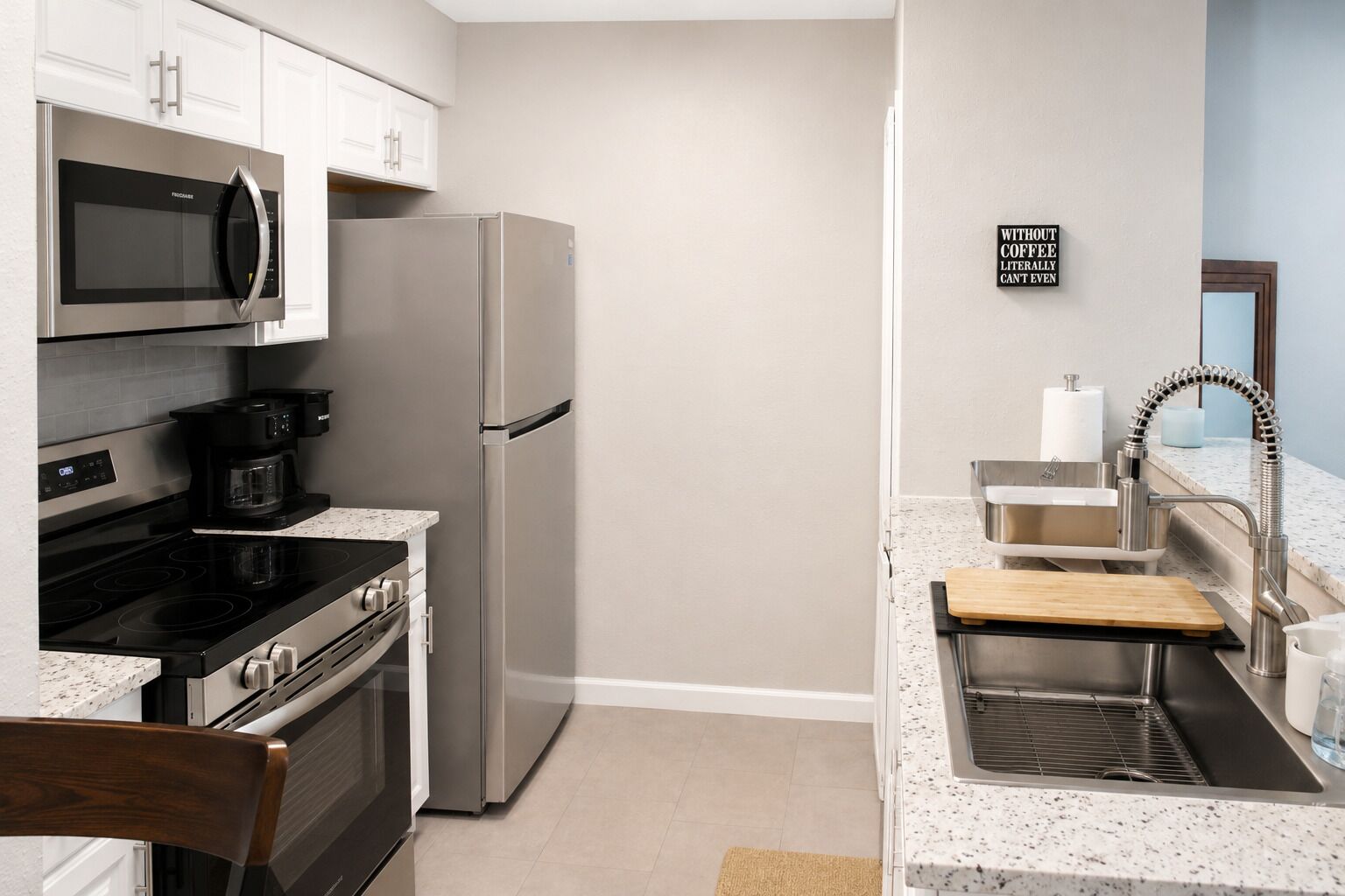 A modern kitchen with stainless steel appliances, a coffee maker, and a sink with a faucet.