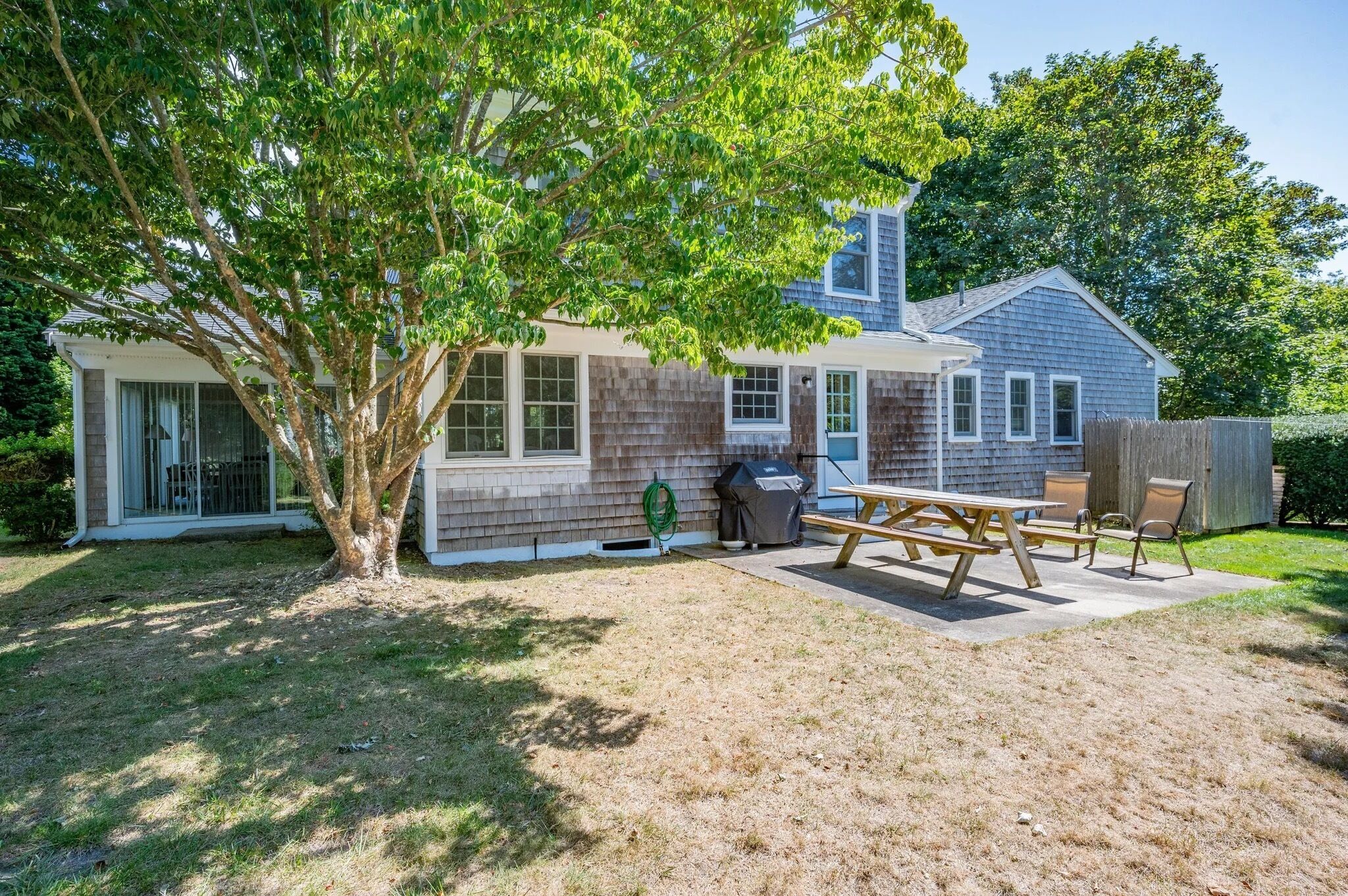 A residential property with a detached house, a covered patio, and a lawn.