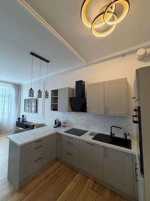 A modern kitchen with marble countertops, a built-in oven, and a stainless steel sink. - StayPrime Wiesbaden Premium Design Apartment 65-inch Smart TV Streaming (Wiesbaden)